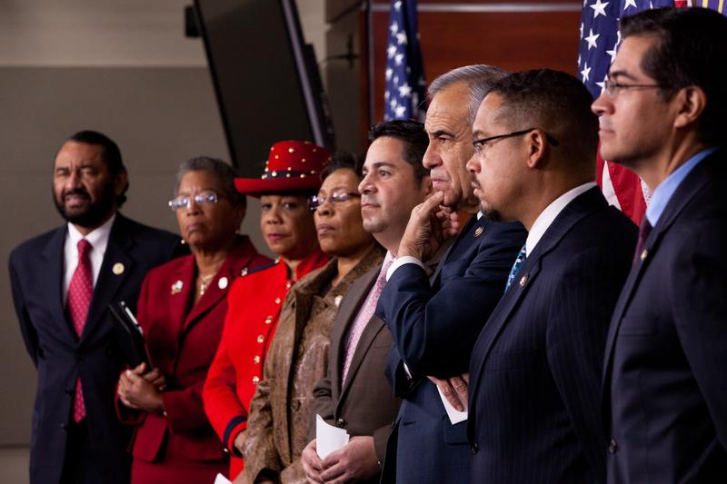 House Democrats listen during a news conference on the negative impact of a health care repeal.